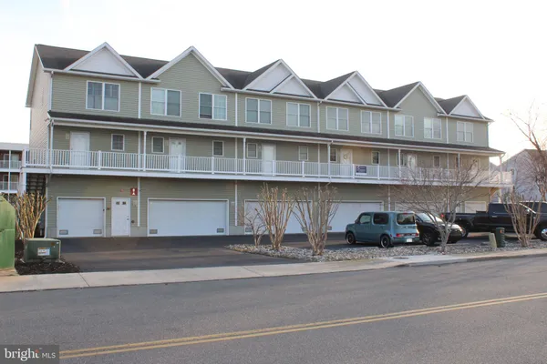 a front view of a house with a garden and plants