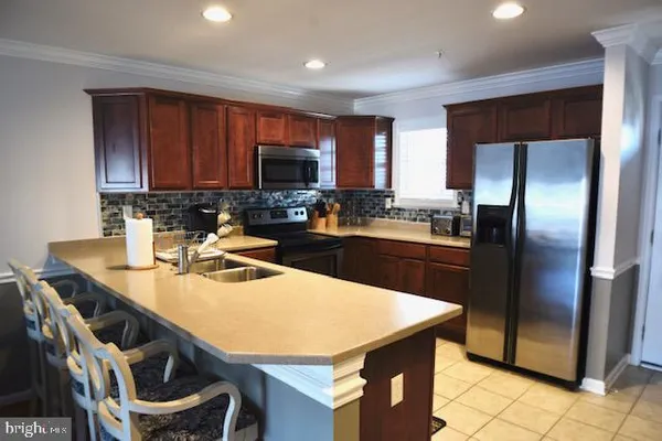 a kitchen with stainless steel appliances granite countertop a stove a refrigerator a sink a microwave and dining table