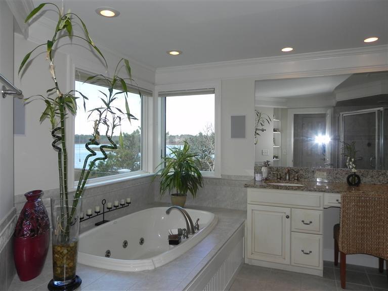 157 Monomoscoy Road Mashpee, MA 02649 - Photo 21 of 28 a bathroom with a bathtub a sink and a window
