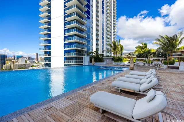 a view of a patio with couches and table potted plants and wooden floor