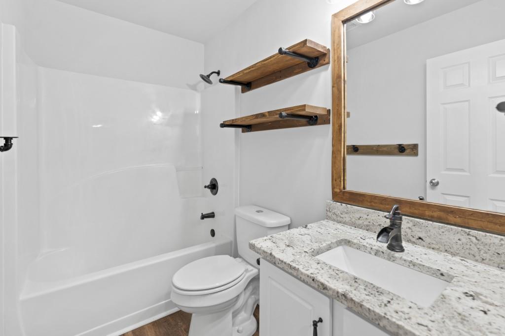 1214 Roxey Maxey Road Southwest Winder, GA 30680 - Photo 18 of 35 a bathroom with a granite countertop sink toilet and shower