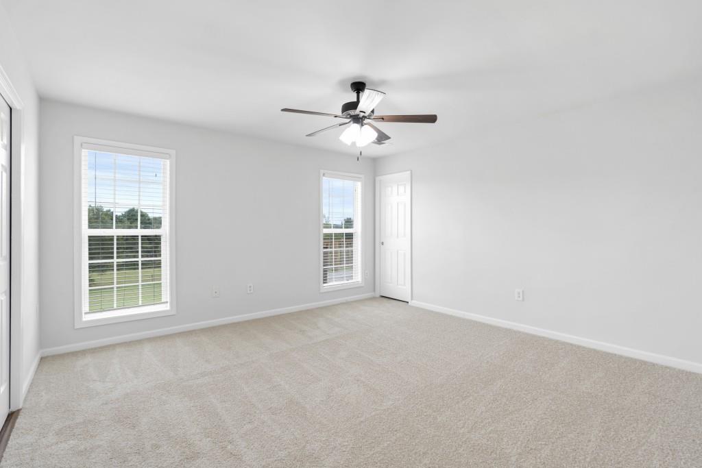 1214 Roxey Maxey Road Southwest Winder, GA 30680 - Photo 19 of 35 an empty room with windows and fan