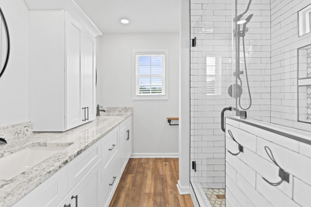 1214 Roxey Maxey Road Southwest Winder, GA 30680 - Photo 22 of 35 a bathroom with a granite countertop sink a mirror and shower