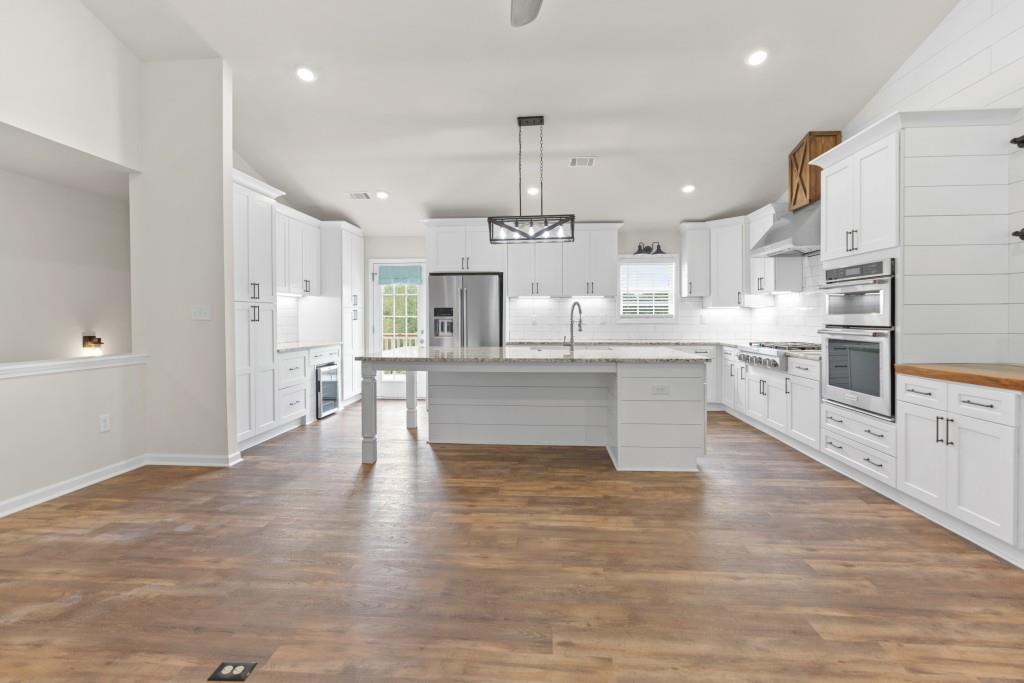 1214 Roxey Maxey Road Southwest Winder, GA 30680 - Photo 7 of 35 a large kitchen with cabinets and wooden floor