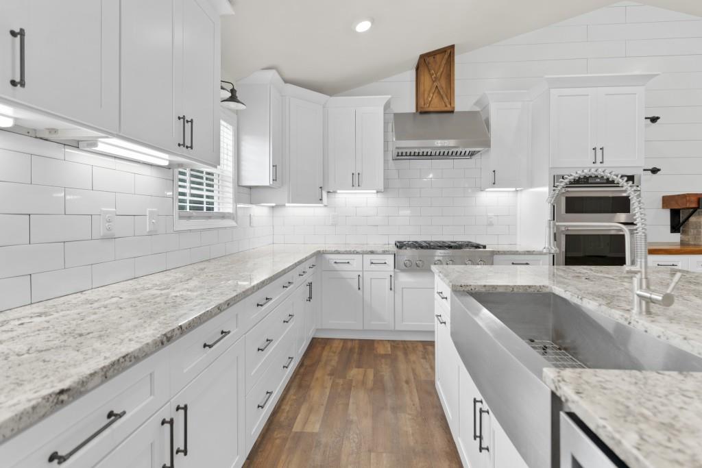 1214 Roxey Maxey Road Southwest Winder, GA 30680 - Photo 8 of 35 a kitchen with granite countertop a sink stove and cabinets