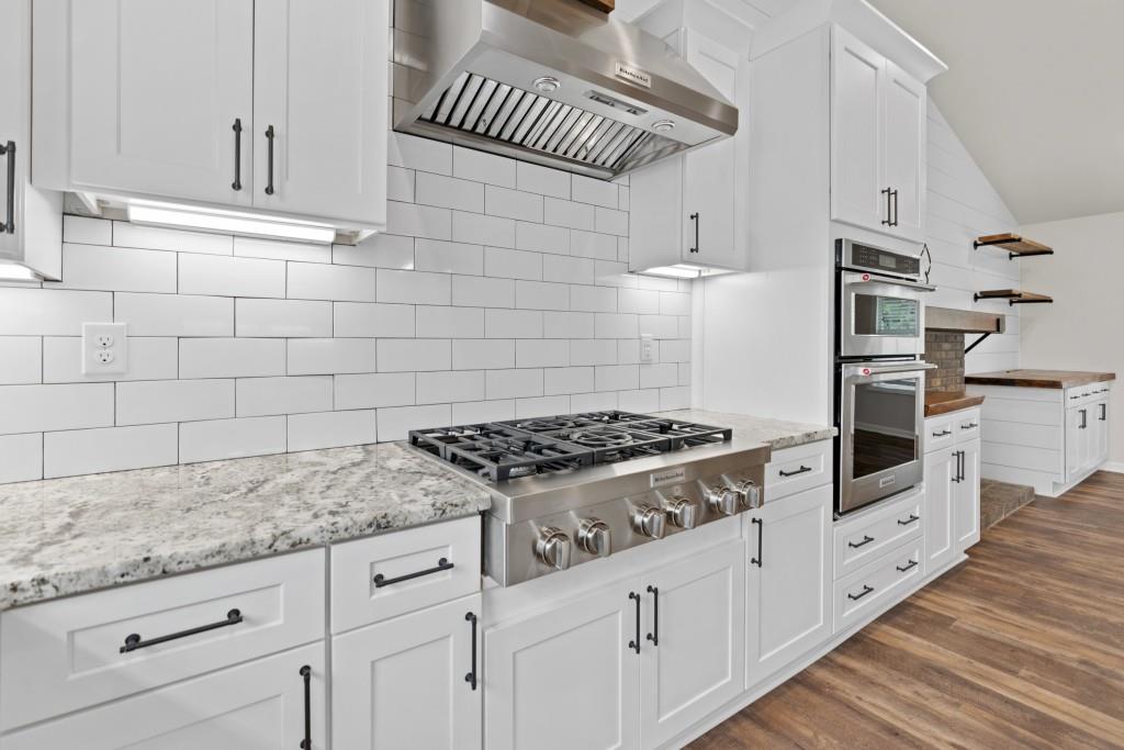 1214 Roxey Maxey Road Southwest Winder, GA 30680 - Photo 9 of 35 a kitchen with granite countertop a stove and a white cabinets