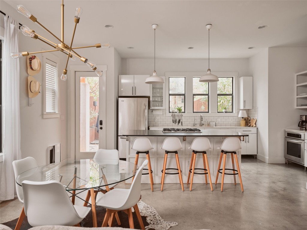 2002 East 13th Street, Unit A Austin, TX 78702 - Photo 13 of 37 Dining room featuring concrete floors and a chandelier