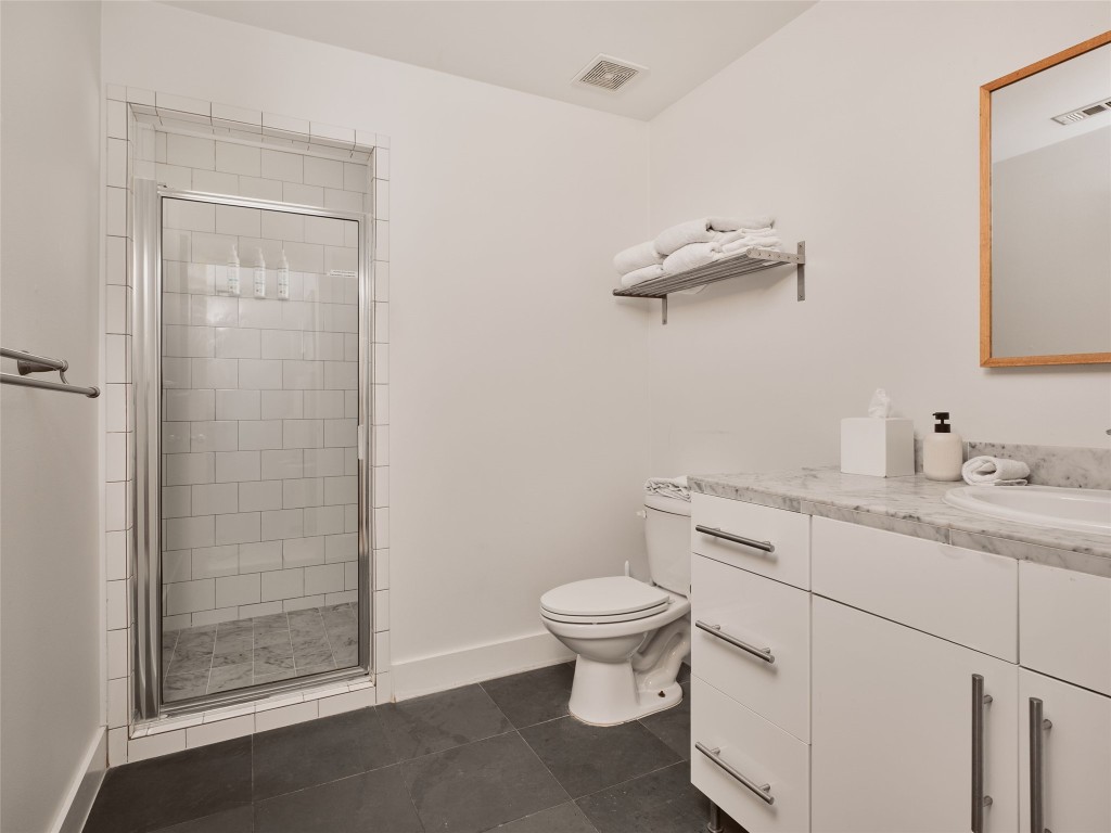 2002 East 13th Street, Unit A Austin, TX 78702 - Photo 28 of 37 Bathroom with vanity, a shower stall, and dark tile patterned flooring