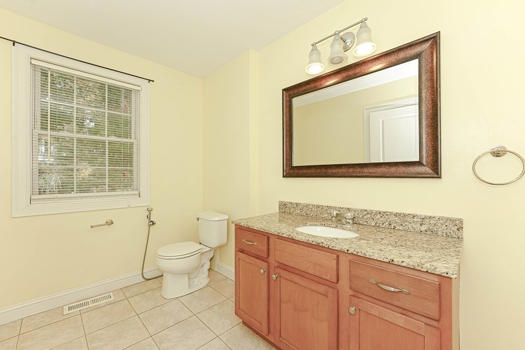 71 Snake Hill Road Ayer, MA 01432 - Photo 18 of 36 a bathroom with a granite countertop toilet sink and mirror