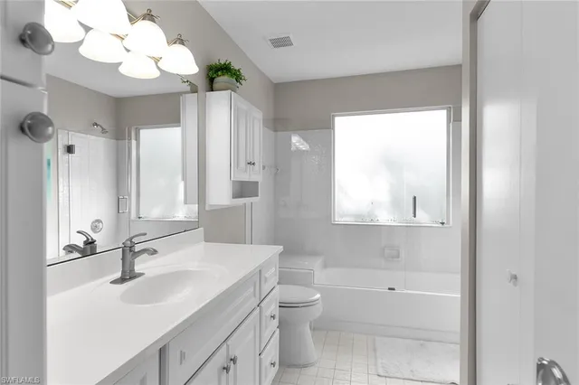 a bathroom with a granite countertop sink a toilet and a mirror