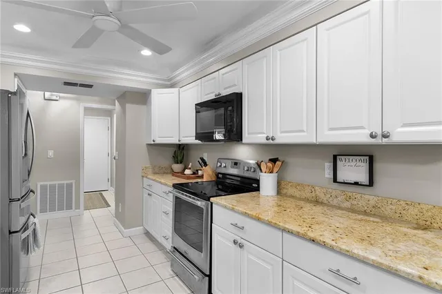 a kitchen with granite countertop white cabinets and stainless steel appliances