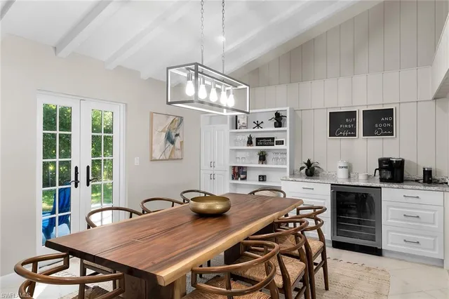 a open kitchen with stainless steel appliances granite countertop a stove a sink dishwasher a dining table and chairs with wooden floor