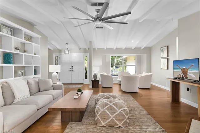a living room with furniture kitchen view and a large window