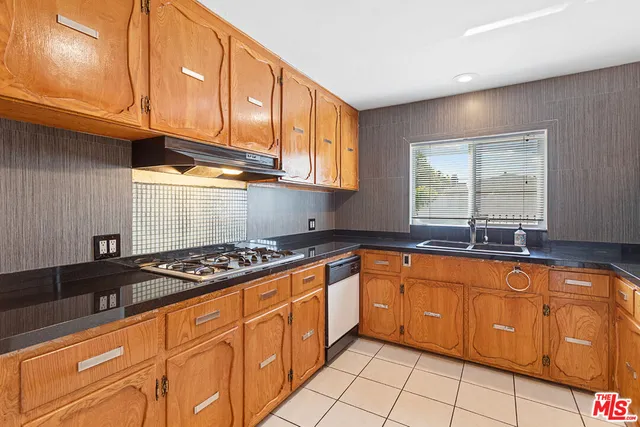 a kitchen with granite countertop a stove sink and cabinets