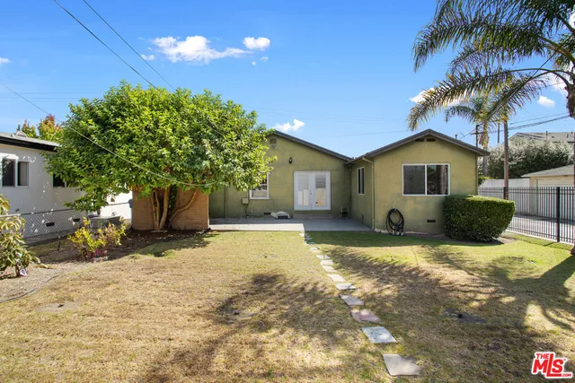 a view of a house with backyard and a garden