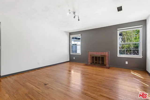 a view of an empty room with window and fireplace