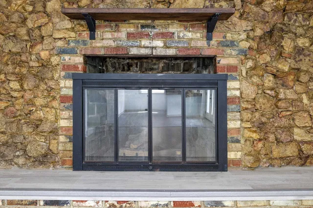 an empty room with ceiling fan and windows