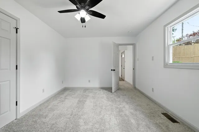 an empty room with closet and windows