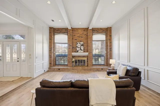 a living room with furniture large window and wooden floor