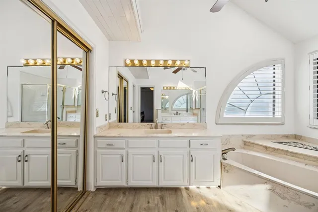 a bathroom with a tub a sink and a large window