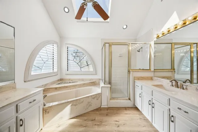 a spacious bathroom with a tub a sink and a window