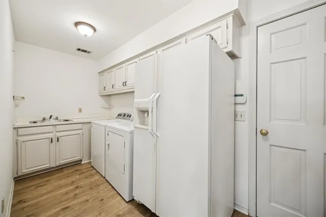 a view of a kitchen with white cabinets and wooden floor