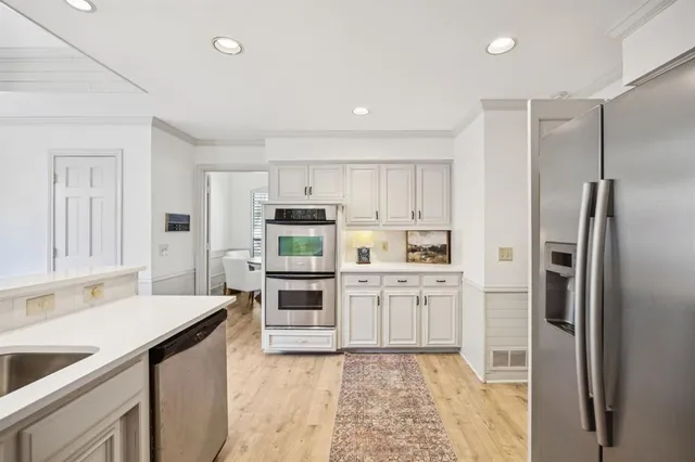 a kitchen with white cabinets and stainless steel appliances