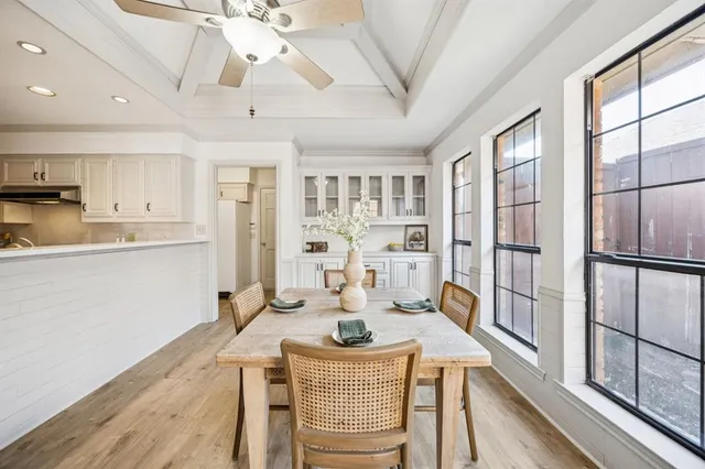 a kitchen with stainless steel appliances granite countertop a refrigerator a stove a sink dishwasher and a dining table with wooden floor