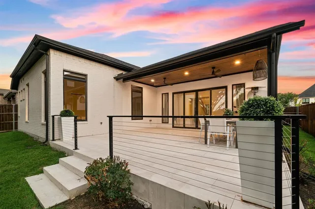 a patio with table and chairs and potted plants