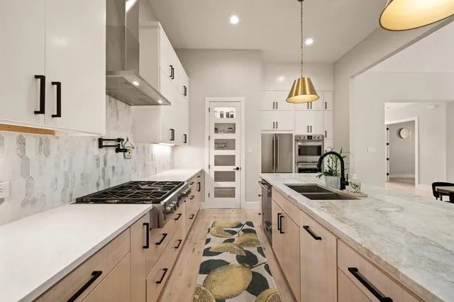 a kitchen with stainless steel appliances a sink stove and refrigerator