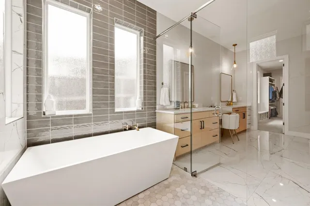 a bathroom with a tub a sink a mirror and a shower