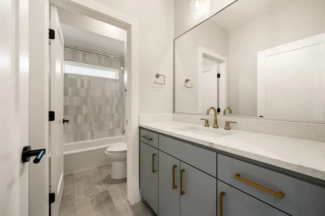 a bathroom with a sink a toilet a mirror and shower