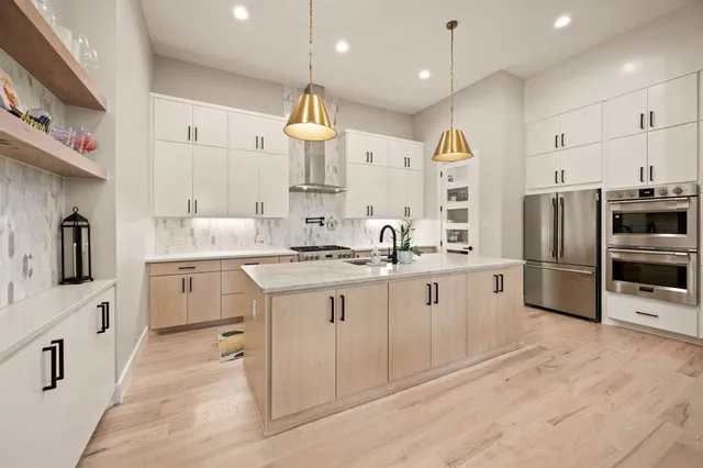 a kitchen with white cabinets and stainless steel appliances