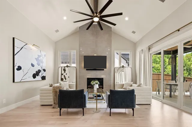 a living room with furniture fireplace and a large window