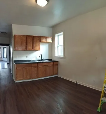a kitchen with granite countertop wooden floors and wooden cabinets
