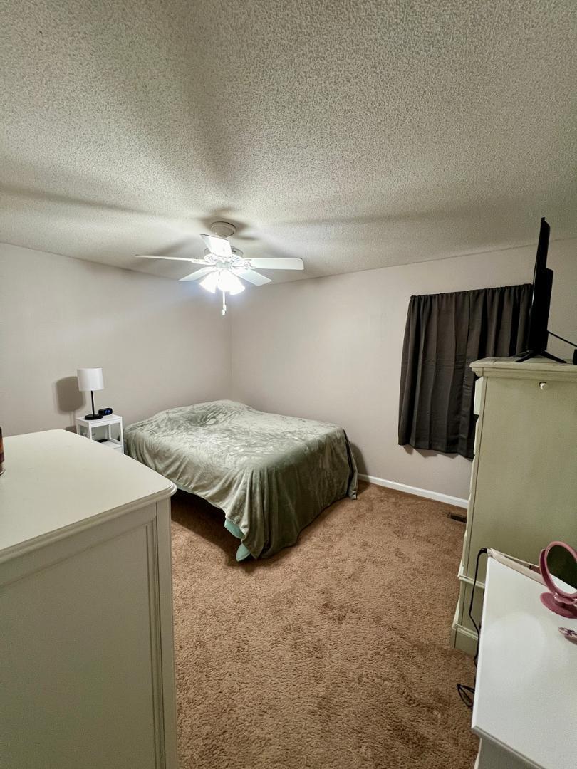 821 Barringer Drive, Unit A Raleigh, NC 27606 - Photo 5 of 8 a bedroom with a bed and a large mirror