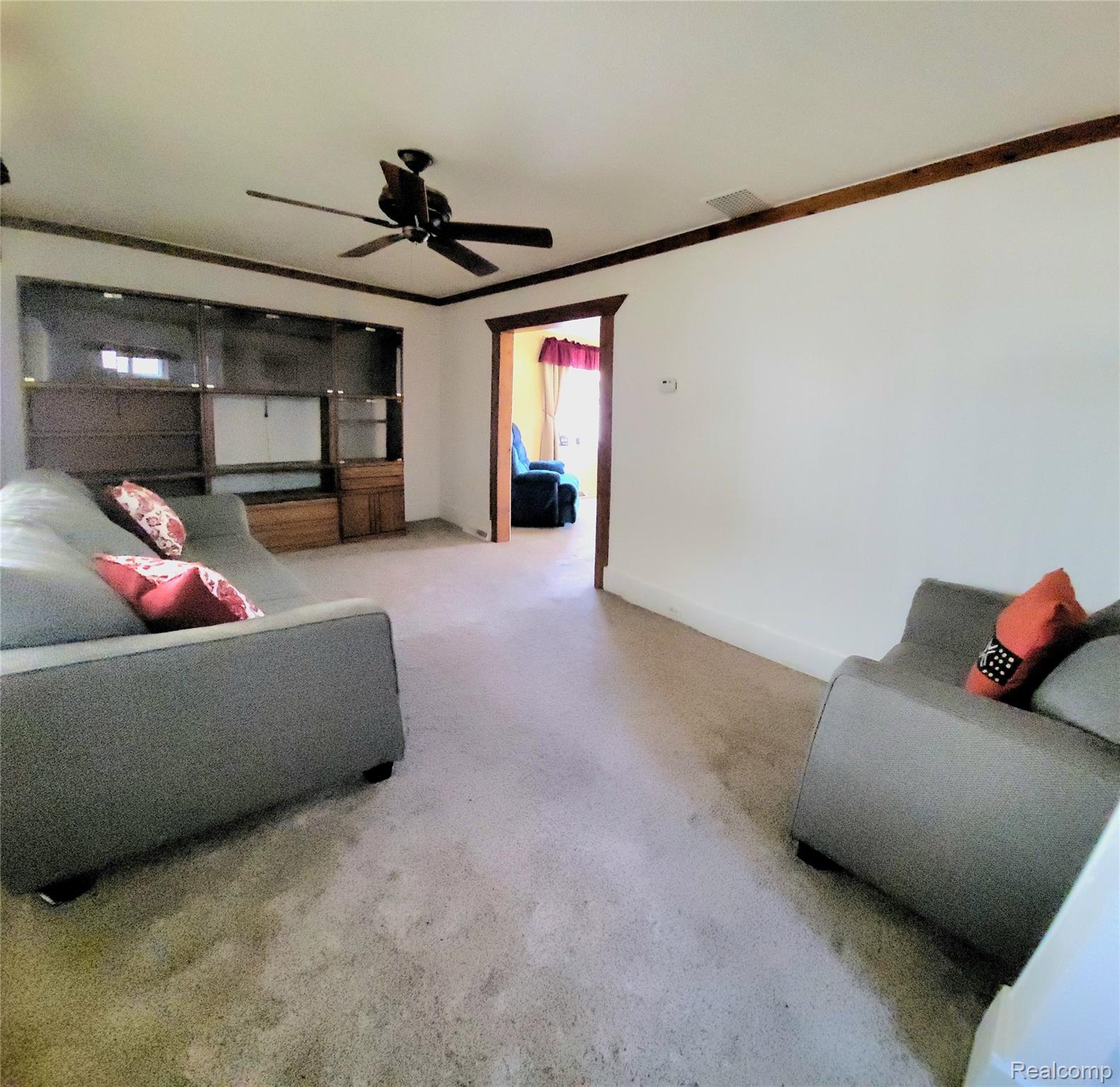 11227 Rivard Avenue Warren, MI 48089 - Photo 13 of 44 Spacious living area featuring a ceiling fan, wall-to-wall carpeting, and wood-trimmed doorways