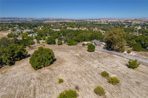 an aerial view of residential houses with outdoor space and trees