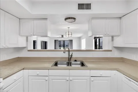 a kitchen with cabinets and chandelier