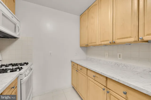 a kitchen with stainless steel appliances granite countertop a sink a stove and a microwave