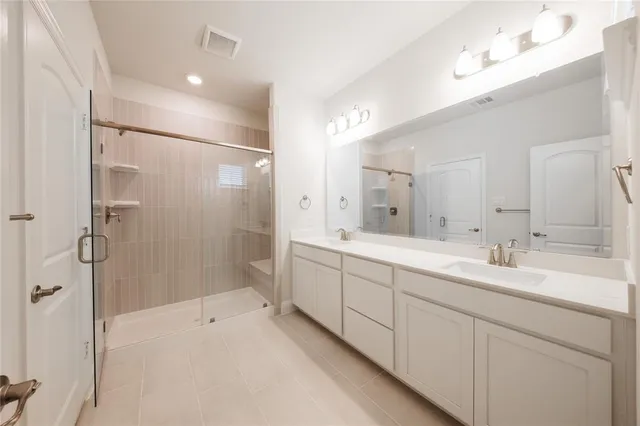 a spacious bathroom with double sink and shower