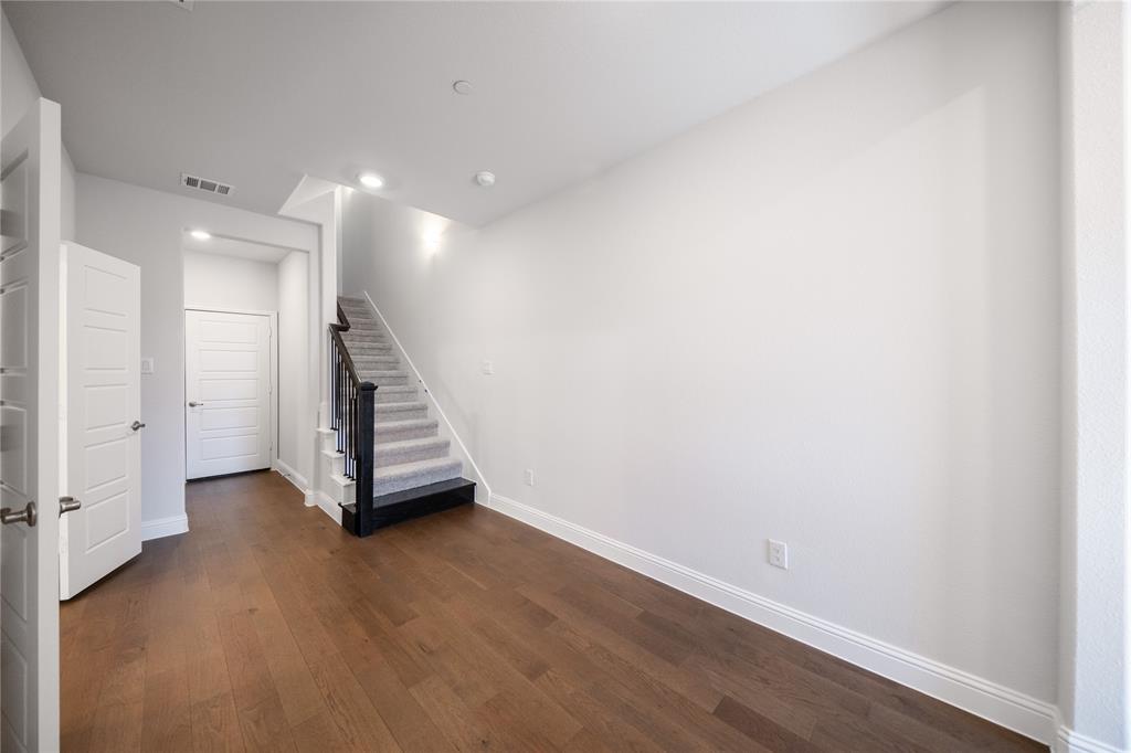 7929 Sunset Boulevard Rowlett, TX 75088 - Photo 14 of 32 an empty room with wooden floor and staircase