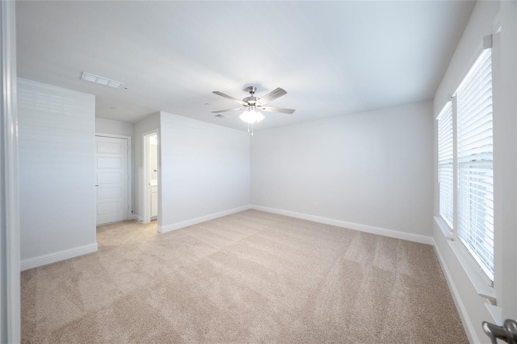 7929 Sunset Boulevard Rowlett, TX 75088 - Photo 20 of 32 an empty room with windows and chandelier fan