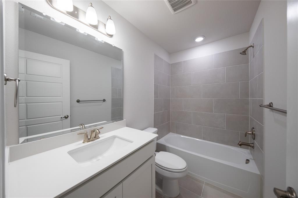 7929 Sunset Boulevard Rowlett, TX 75088 - Photo 22 of 32 a bathroom with a sink a toilet a mirror and bathtub