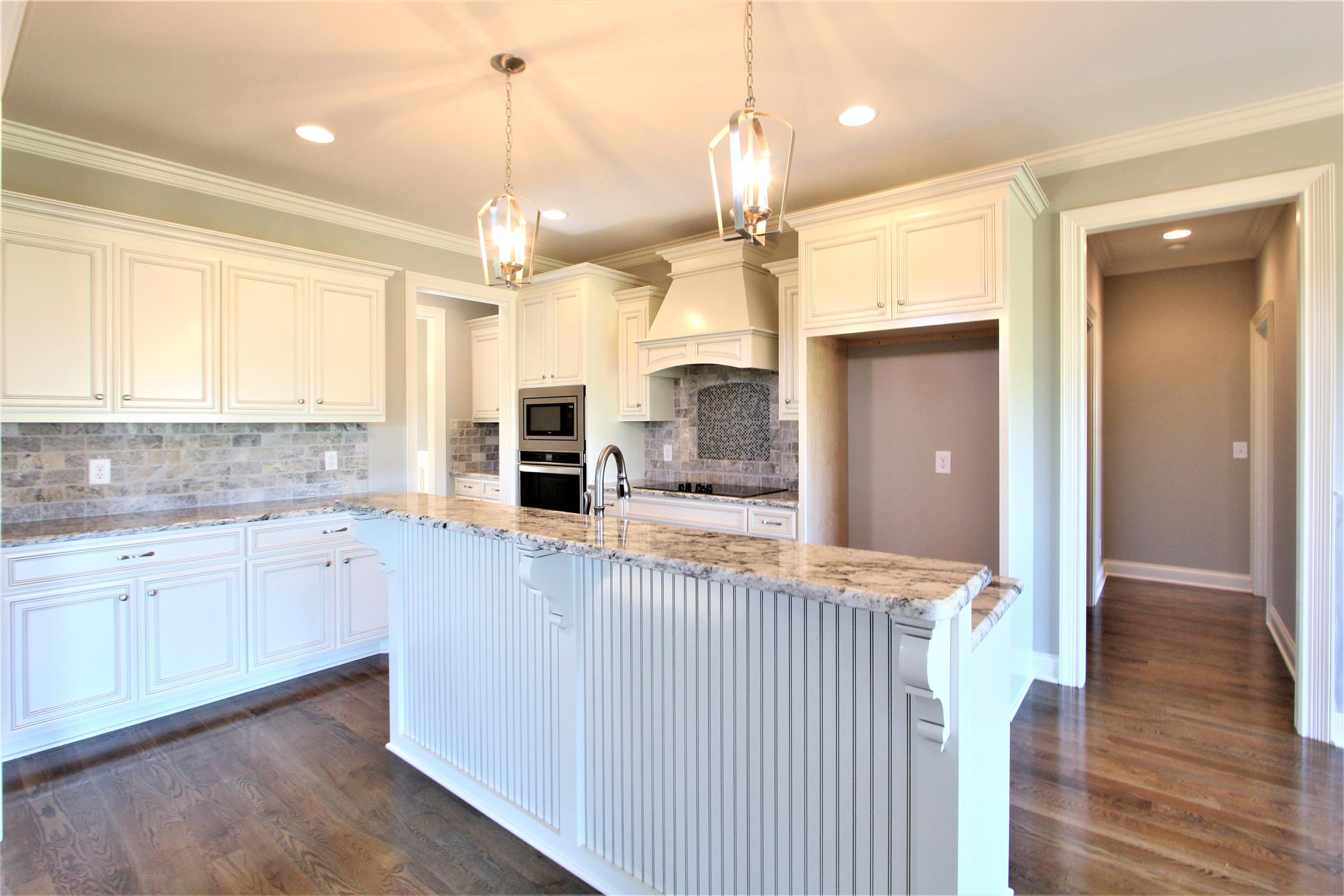 3818 Old Murfreesboro Road West, Unit 5 Lebanon, TN 37090 - Photo 13 of 27 a large kitchen with granite countertop a large center island a sink stainless steel appliances and cabinets