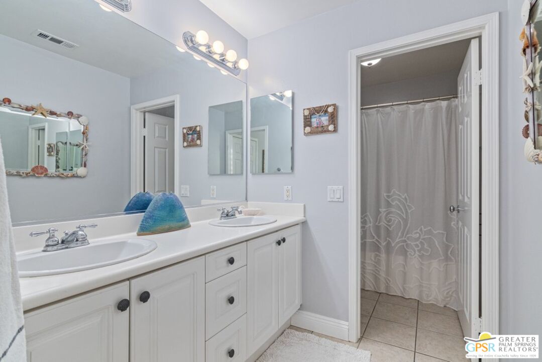 45211 Willowick Street Temecula, CA 92592 - Photo 39 of 69 a bathroom with a double vanity sink and a mirror