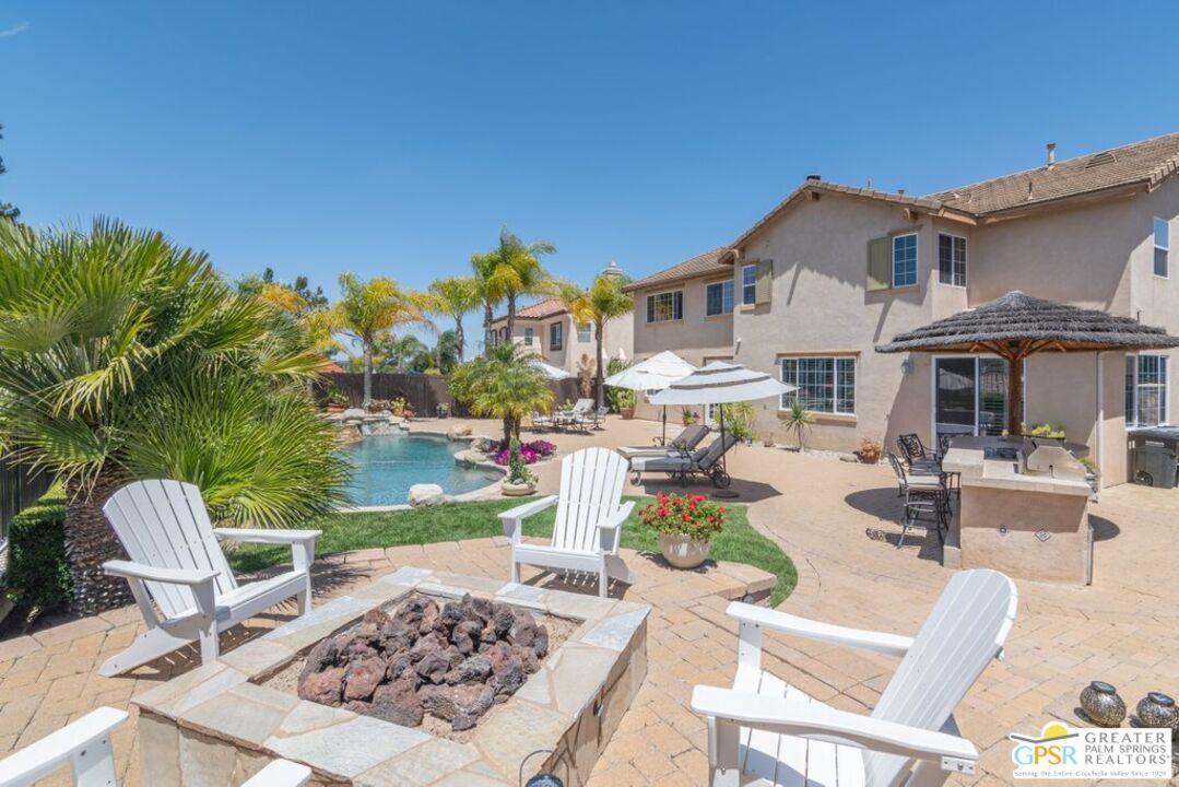 45211 Willowick Street Temecula, CA 92592 - Photo 49 of 69 a view of a patio with couches table and chairs under an umbrella