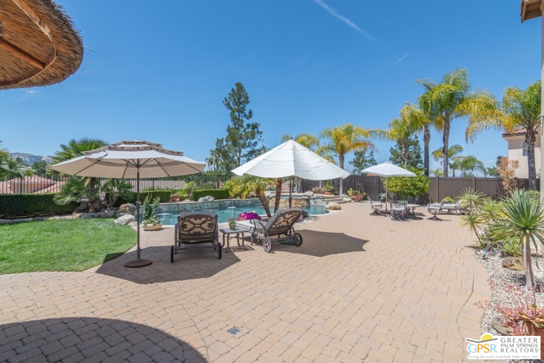 45211 Willowick Street Temecula, CA 92592 - Photo 52 of 69 a view of a backyard with a patio table and chairs under an umbrella