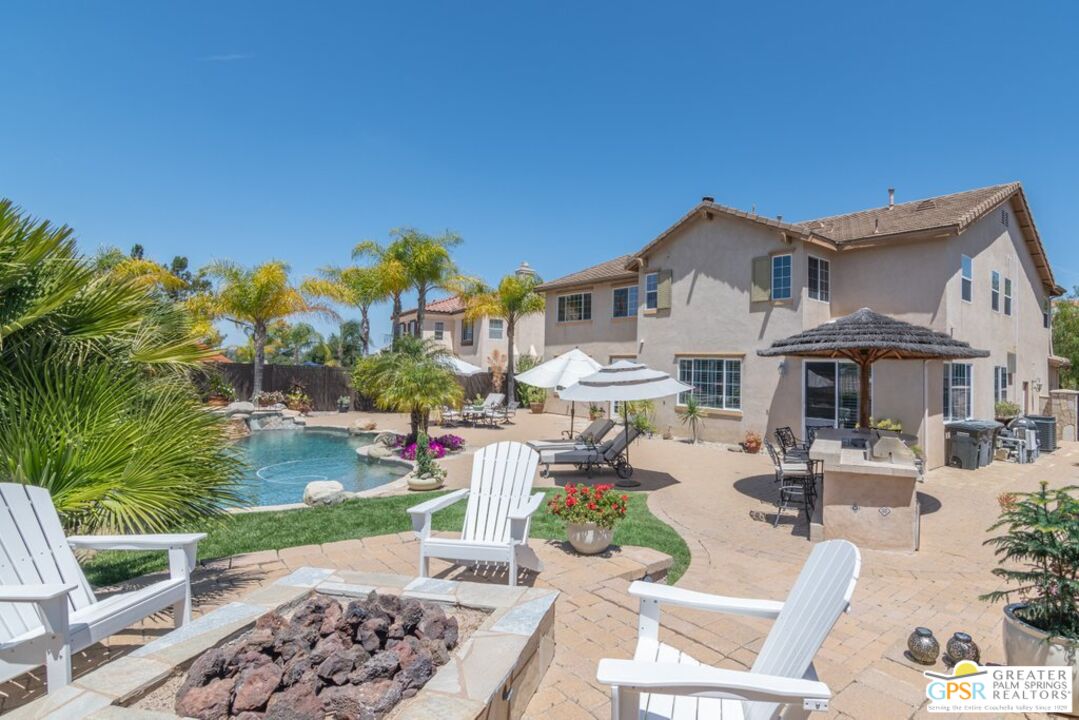 45211 Willowick Street Temecula, CA 92592 - Photo 59 of 69 a view of a patio with table and chairs potted plants and palm trees