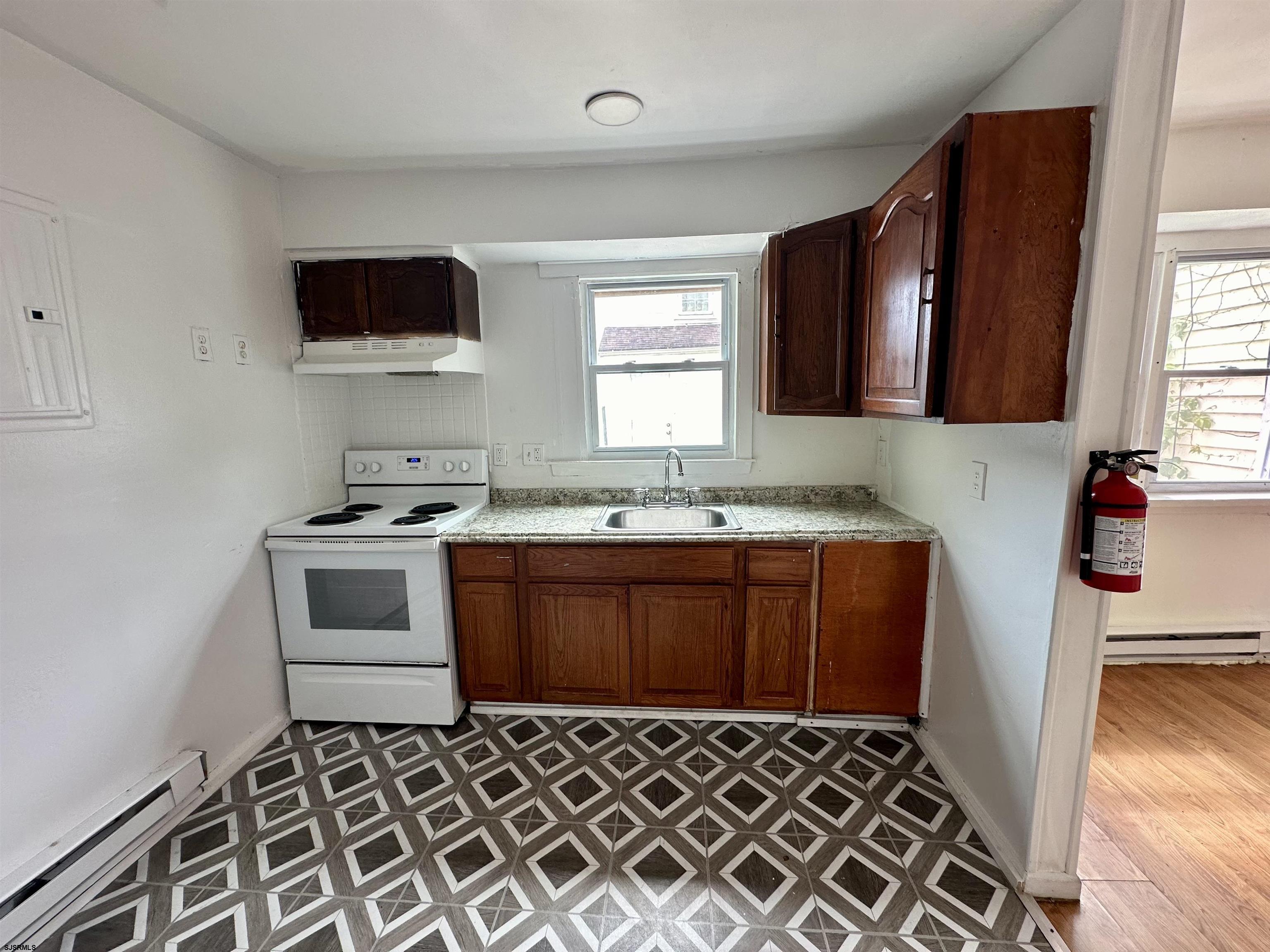 2521 Centennial Avenue, Unit 1 Atlantic City, NJ 08401 - Photo 3 of 8 a kitchen with granite countertop a stove a sink and a microwave